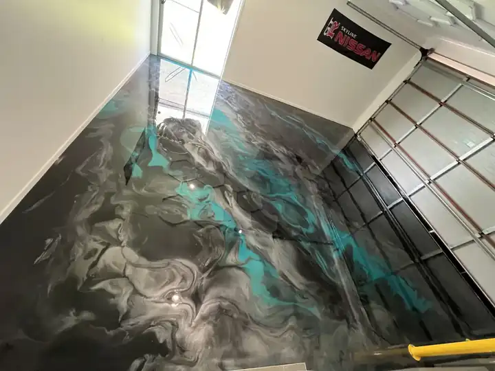 Blue-green metallic epoxy floor in a shop